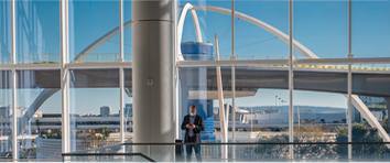 Man standing in front of large window at LAX airport.